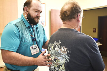 male provider checking male patient heart