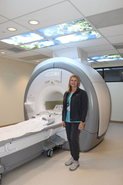 Female Nurse standing next to an MRI Scanner